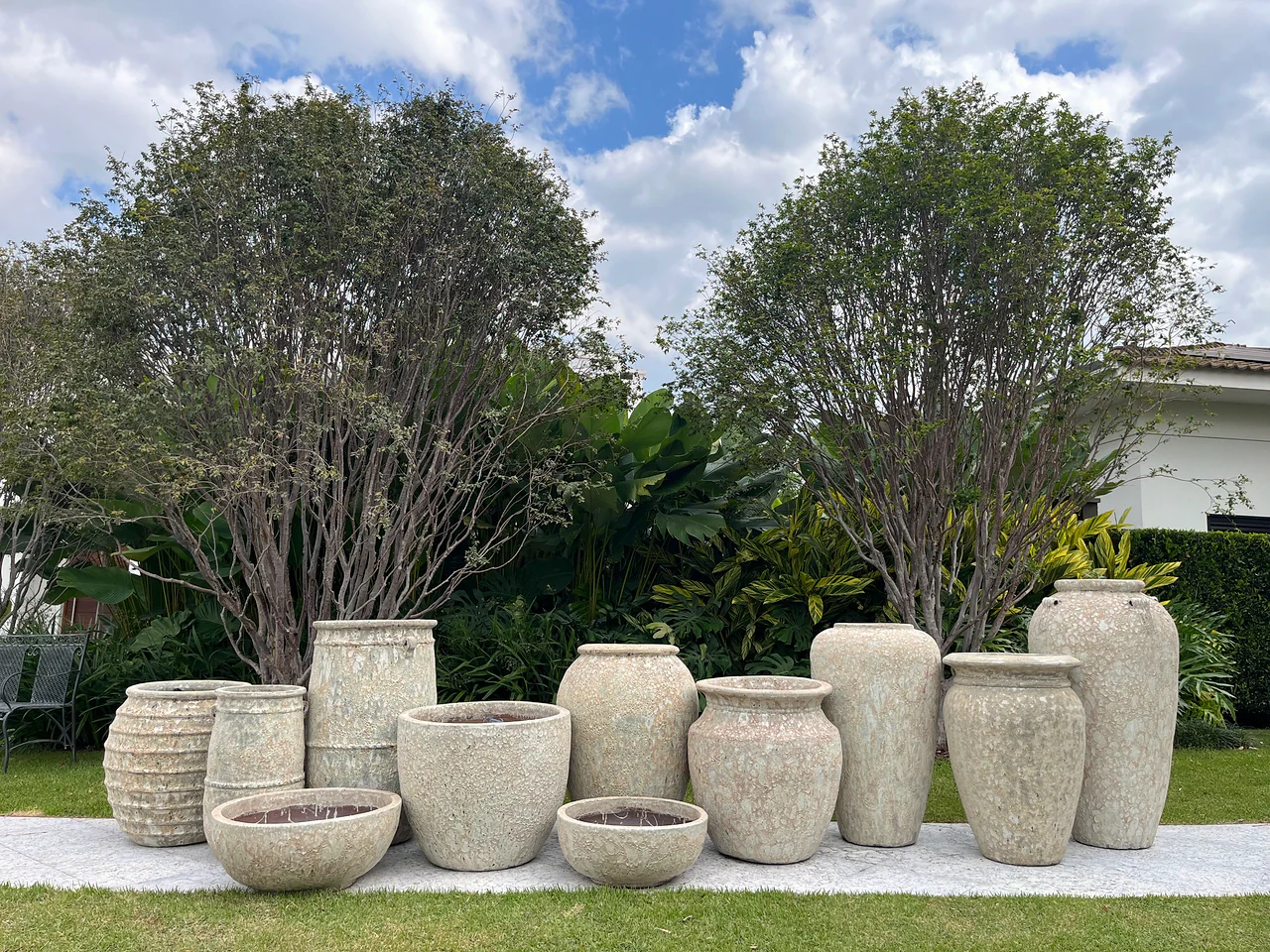 Vasos Portofino em argila vulcânica compondo jardim entre árvores